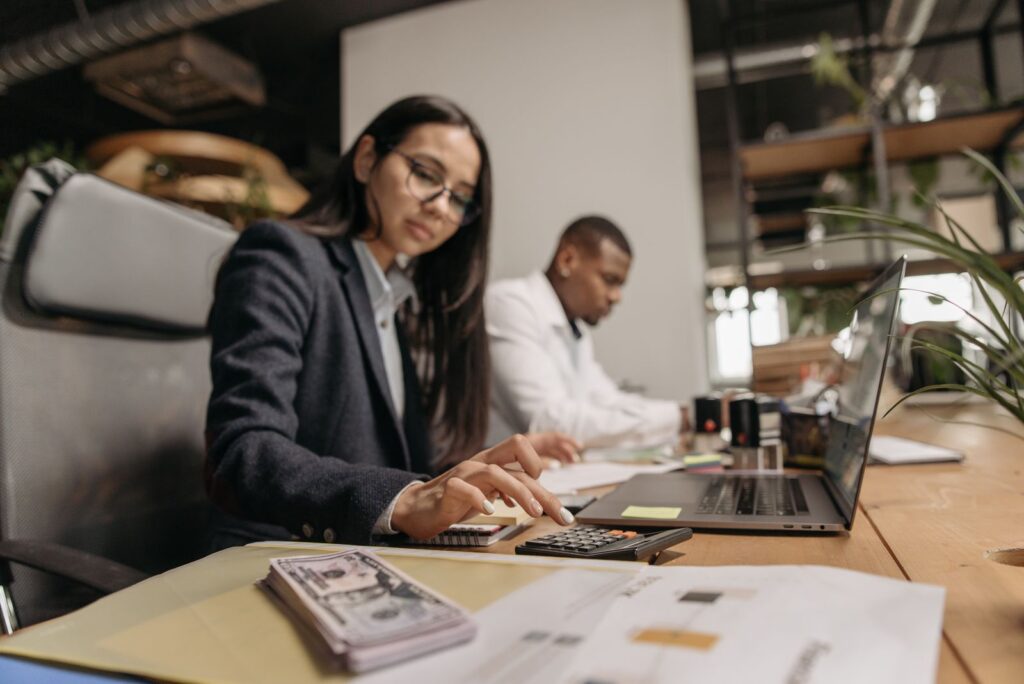 Profesionales trabajando con portátil y calculadora en oficina